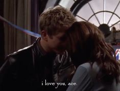 a young man and woman kissing in front of a large clock with the words i love you, ace