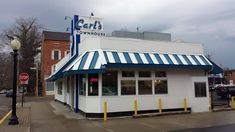 a white building with a blue and white awning