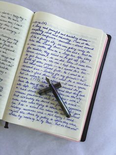 an open notebook with writing on it and a fountain pen resting on the book's page