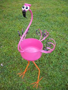 a pink flamingo is standing on its legs in the grass with scissors and eyeballs