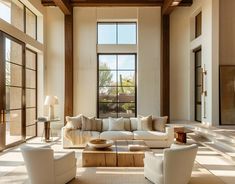 a living room filled with lots of furniture and large windows in the middle of it