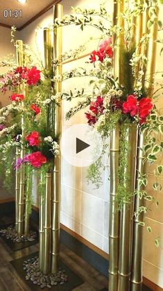 three tall gold vases with flowers in them