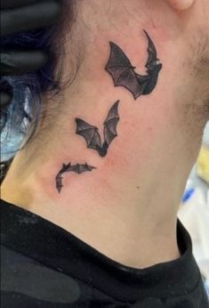 a man with a bat tattoo on his neck