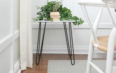 a small white table with some plants on it