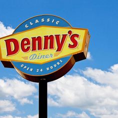 the sign for denny's diner in front of a blue sky with clouds