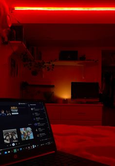 an open laptop computer sitting on top of a table in front of a red light