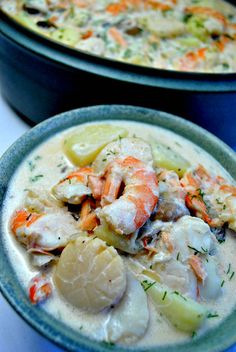 two bowls filled with seafood and vegetables on top of a table