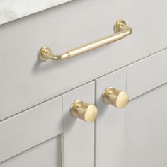 the handles and knobs on this kitchen cabinet are gold