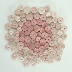 a group of pink buttons sitting on top of a white table next to each other