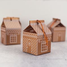 three small cardboard houses are sitting on the table