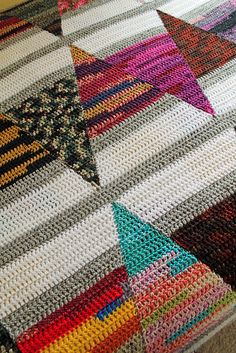 a crocheted blanket with many different colors and shapes on the bottom, along with a star