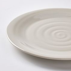 a white plate on a white surface with ripples in the middle and one circle at the center