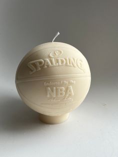 a white candle with the words spalding on it sitting in front of a white background