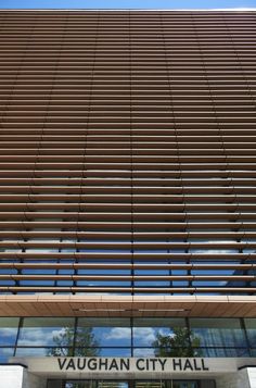 the front entrance to vaugh city hall with its glass windows and wooden slats