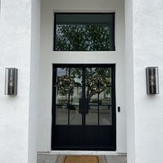 the front door is decorated with wreaths and glass doors that lead to an entrance