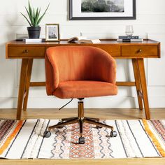 an orange chair sits in front of a desk with a potted plant on it