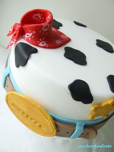 a cake with black and white polka dots on it, topped with a red bow