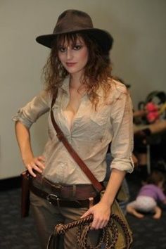 a woman wearing a hat and holding a purse