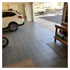 a white car parked in a garage next to a bike and table with boxes on it