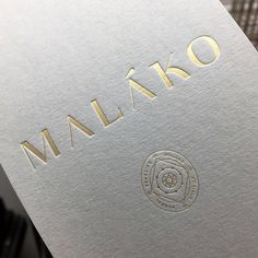 a close up view of the logo on a wine bottle that is white and gold