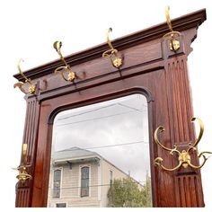 a large mirror with gold handles on the front of it and a house in the background