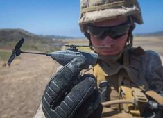 a soldier holding a remote control device in his hand