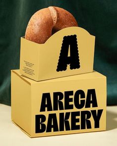 an open box with a bagel in it that says area bakery on the side