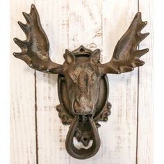 a metal deer head mounted to the side of a white wooden wall next to a door