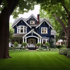 a blue house with white trim and trees in the front yard is surrounded by lush green grass