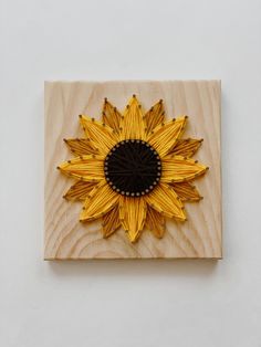 a sunflower made out of pasta sitting on top of a wooden block