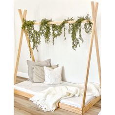 a bed that has some plants growing on the top and bottom of it, along with pillows