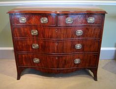 an antique chest of drawers with metal pulls and knobs on the top, sitting against a wall