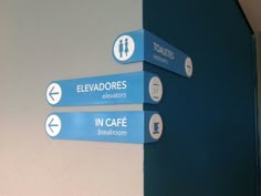 three blue and white signs pointing in different directions on the wall next to each other