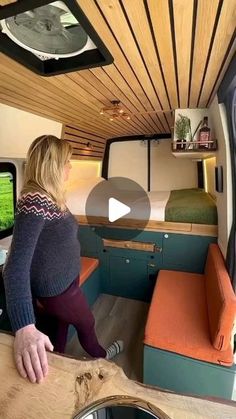 a woman standing in front of a tv inside of a camper