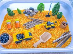 this is a cake made to look like construction vehicles in the sand and grass with rocks