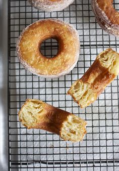 several doughnuts on a cooling rack with powdered sugar