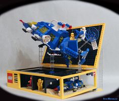 an open lego box with a blue and yellow machine in it's display case