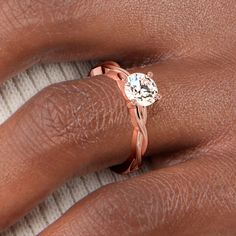 a woman's hand with a rose gold ring on her finger and a diamond in the middle