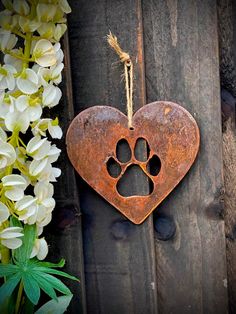 a heart shaped metal ornament with a dog's paw on it