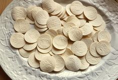 a white plate topped with lots of cookies on top of a wooden table