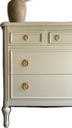 a white dresser with gold handles and knobs on it's drawers, against a white background