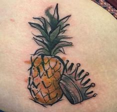 a pineapple tattoo on the back of a woman's stomach