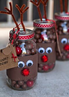 four mason jars with reindeer noses and candy in them, one has a tag on it