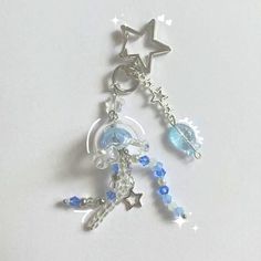 a keychain with an angel and star charm on it's side, hanging from a chain