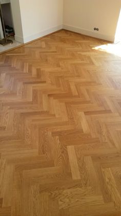 an empty room with hard wood floors and white walls