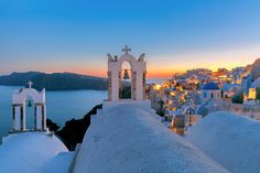 an image of a church on top of a hill overlooking the ocean at sunset or dawn