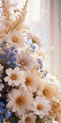 a bouquet of white and blue flowers in front of a window