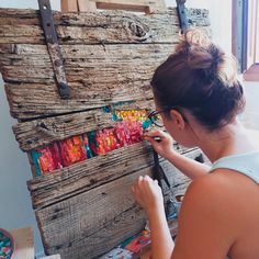 a woman is painting an art project on wood planks with colored paint and acrylic