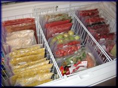 an open refrigerator filled with lots of food and plastic bags on top of the shelves