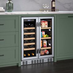 a wine cooler in the middle of a kitchen with green cabinets and countertop space